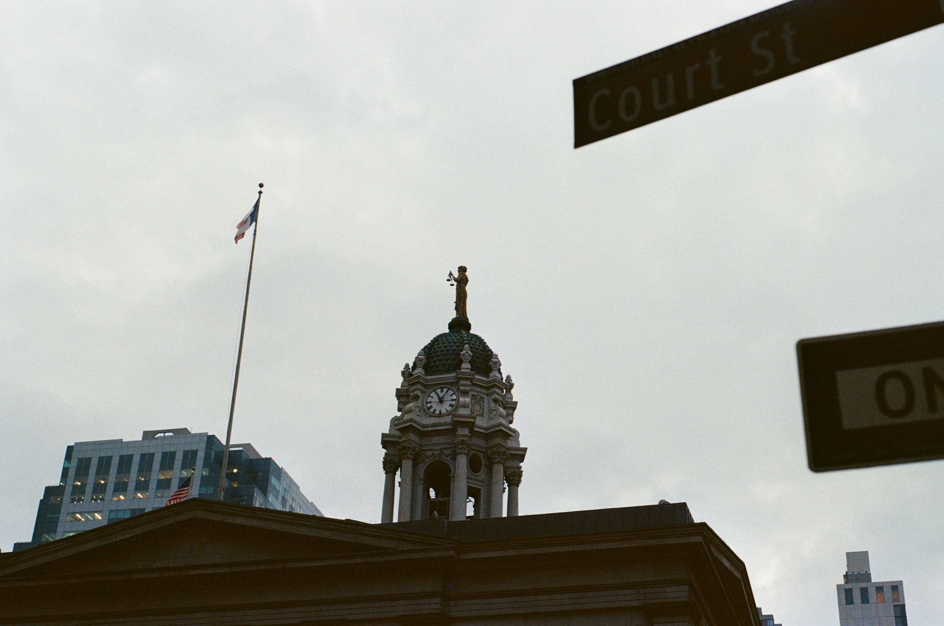 A historic courthouse with a clock tower and flag